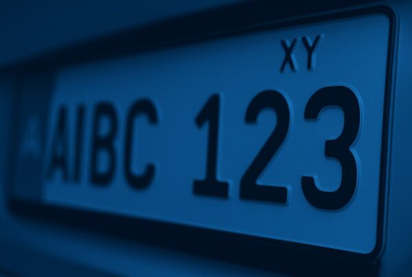 Are vehicle registration plates personal data? Close-up of a vehicle license plate in cool blue tones, highlighting the numbers and letters in sharp focus.
